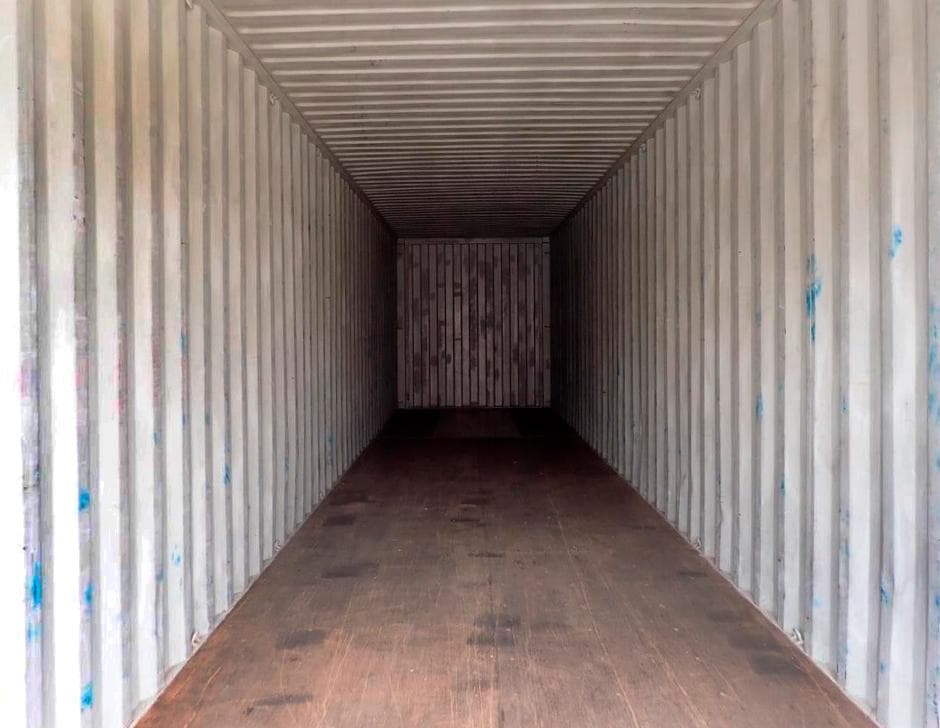 Interior de contenedor marítimo usado, con piso de madera desgastado