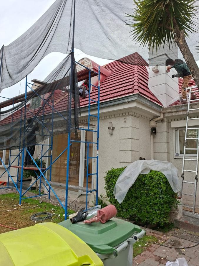 Casa con andamios montados y trabajos en la techumbre