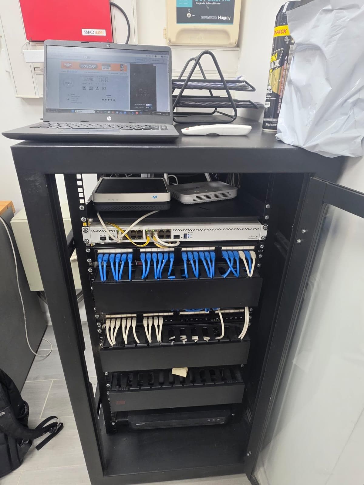 Rack de comunicaciones con patch panels, switch y cableado ordenado